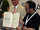 Gosho Aoyama mit seiner Zeichnung im goldenen Buch von Erlangen